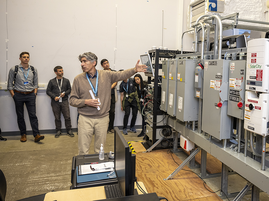 A person explaining large electrical panels to a group