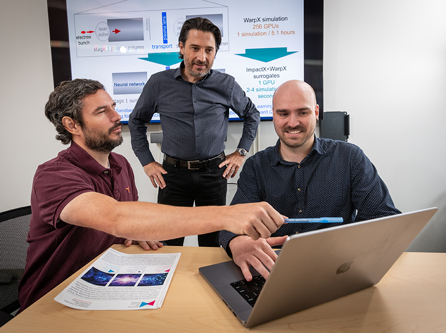 Three people looking at laptop