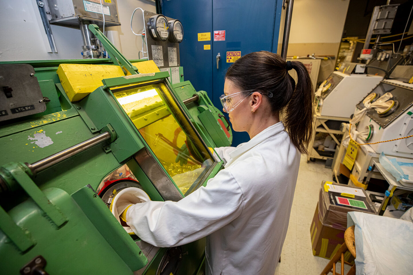 A researcher in PPE operating a green machine