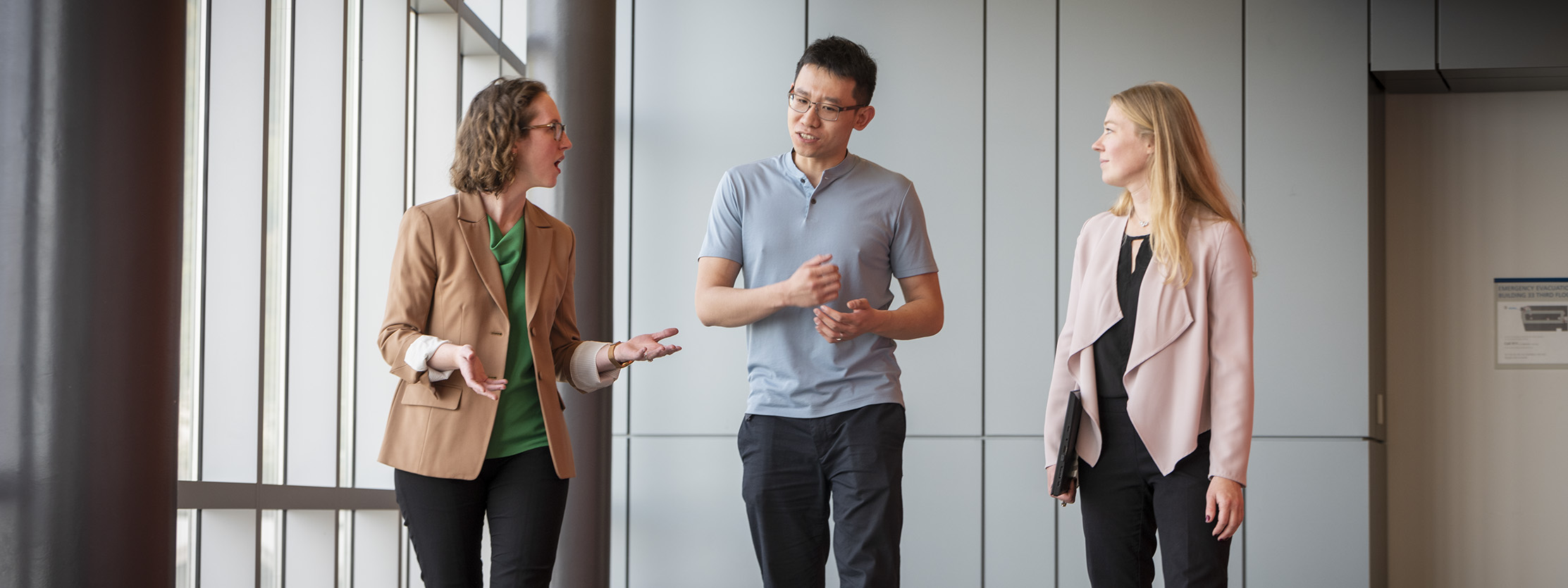 Three people chatting in hallway